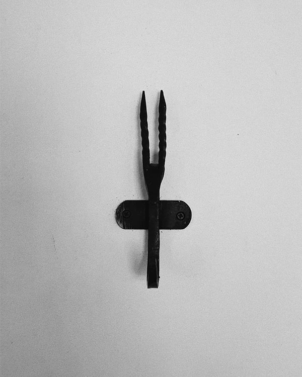 A single hook made of metal, oxide, screwed to a wall. Found on a private home in Malinalco, Mexico, 2020.