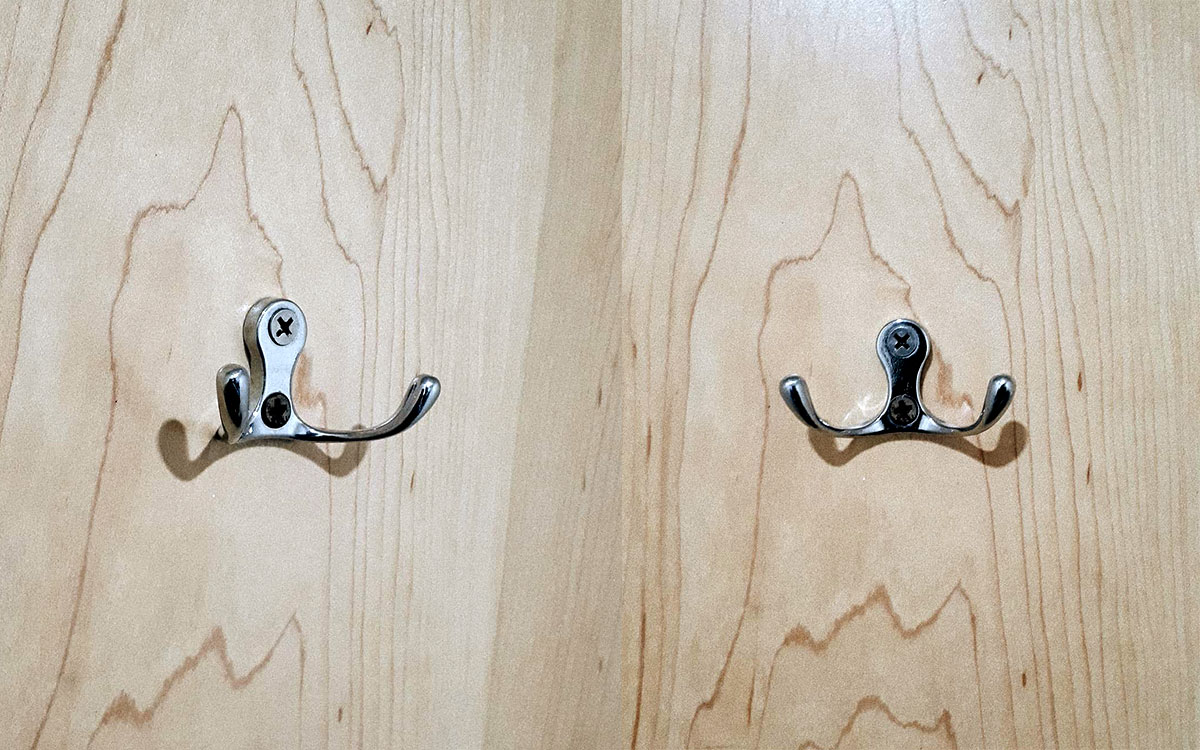 A double hook made of metal, chrome, screwed to a door. Found on a restaurant in Mexico City, Mexico, 2019.