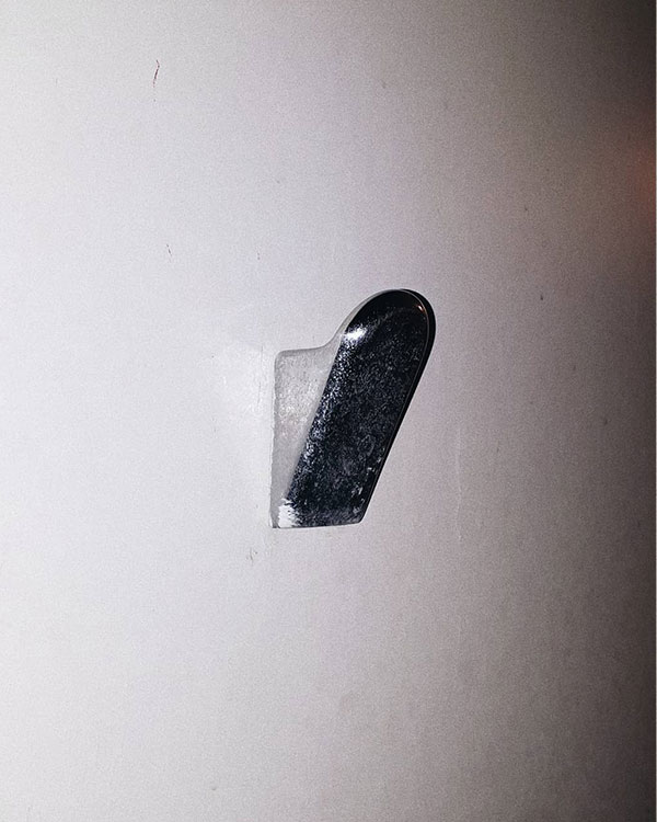 A single hook made of metal, chrome, fixed to a wall. Found in a private home at Sanary-sur-Mer, France, 2020.