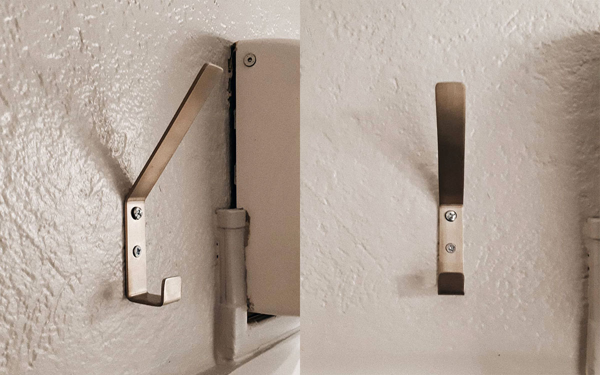 A double hook made of metal, nickel, screwed to a wall. Found on a restaurant in Lyon, France, 2021.