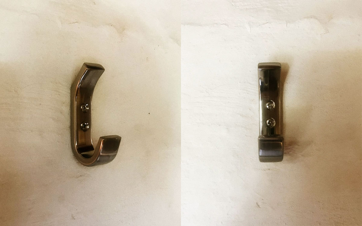 A double hook made of metal, brass, screwed to a wall. Found on a private home in Malinalco, Mexico, 2021.