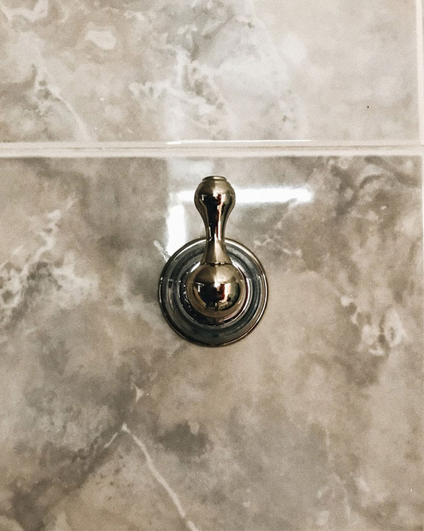 A single hook made of metal, chrome, fixed to a wall. Found on a private home in Acapulco, Mexico, 2022.