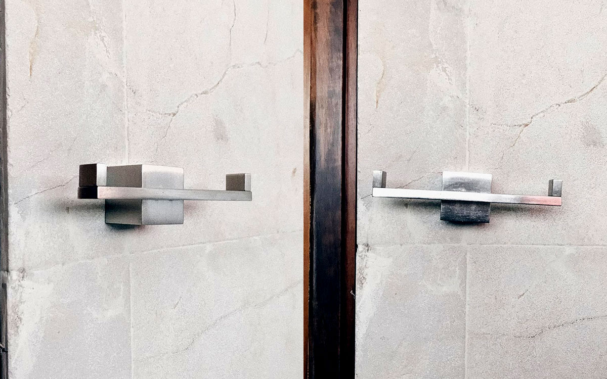 A double hook made of metal, nickel, screwed to a wall. Found on a private home in Tepoztlan, Mexico, 2022.