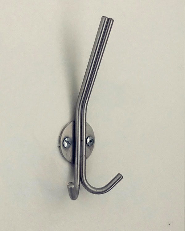 A triple hook made of metal, nickel, screwed to a wall. Found on a hospital in Mexico City, Mexico, 2022.