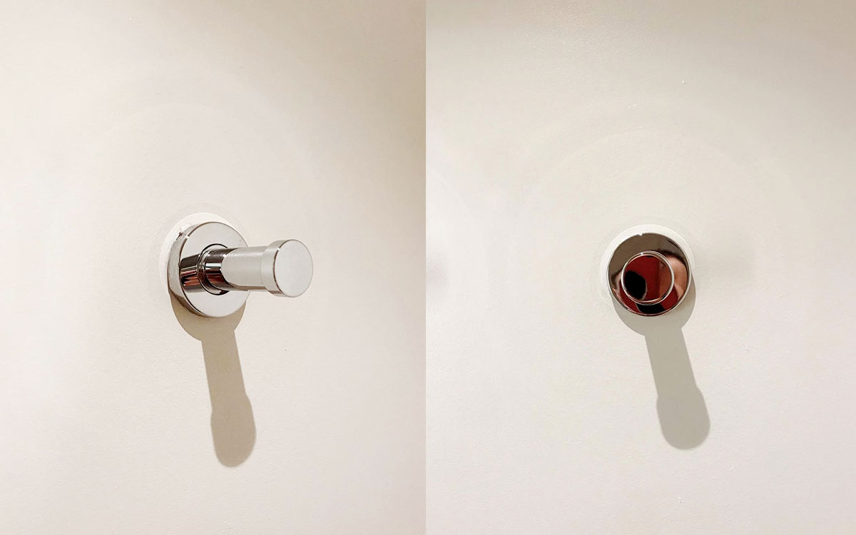A single hook made of metal, chrome, screwed to a wall. Found on a hotel in Carcassonne, France, 2022.