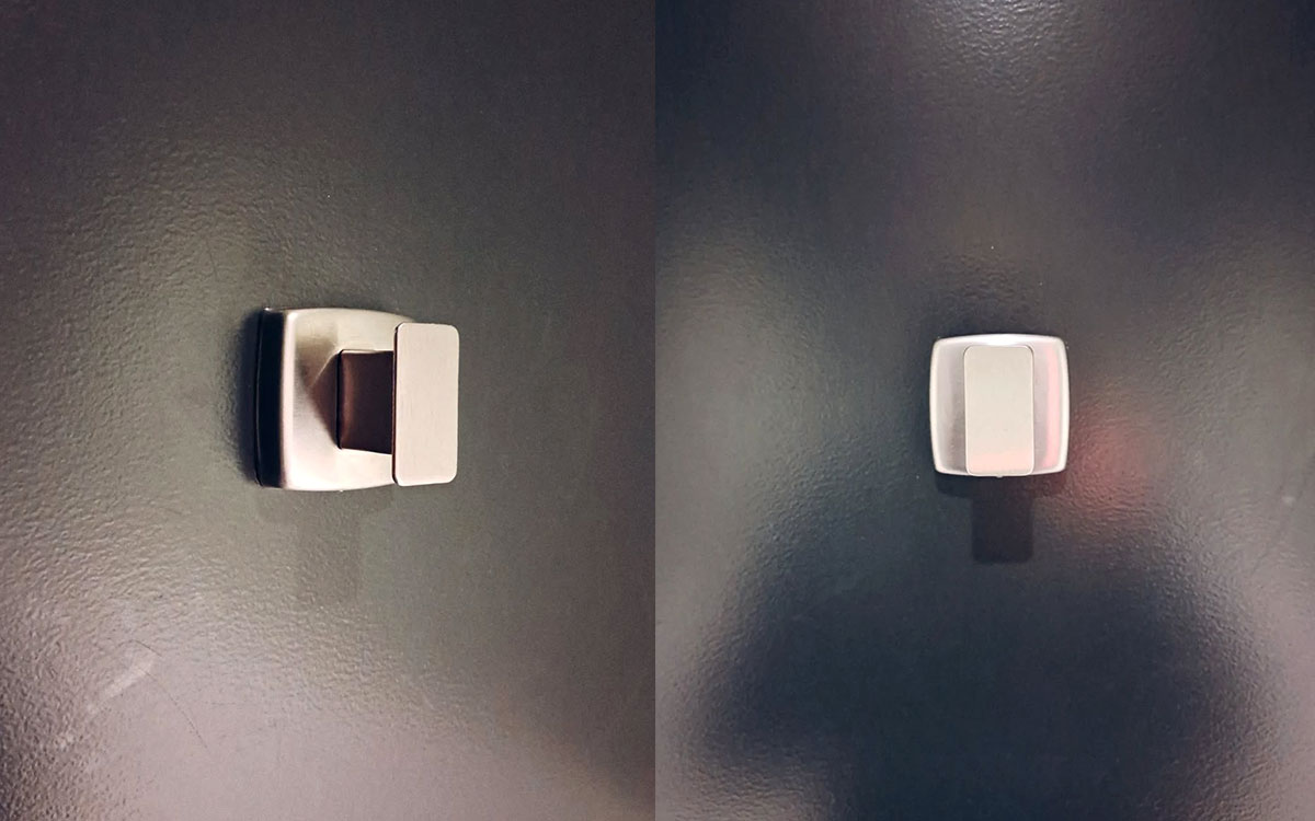 A single hook made of metal, nickel, screwed to a door. Found at Montreal Science Centre in Montreal, Canada, 2024.