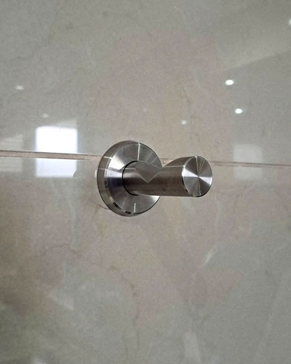 A single hook made of metal, nickel, screwed to a wall. Found at Club Mundet in Mexico City, Mexico, 2024.