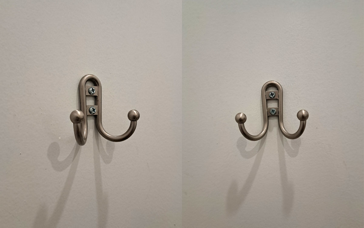 A double hook made of metal, nickel, screwed to a door. Found on a restaurant in New York, USA, 2025.