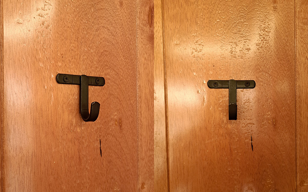 A single hook made of metal, nickel, screwed to a door. Found on a restaurant in Mexico City, Mexico, 2025.