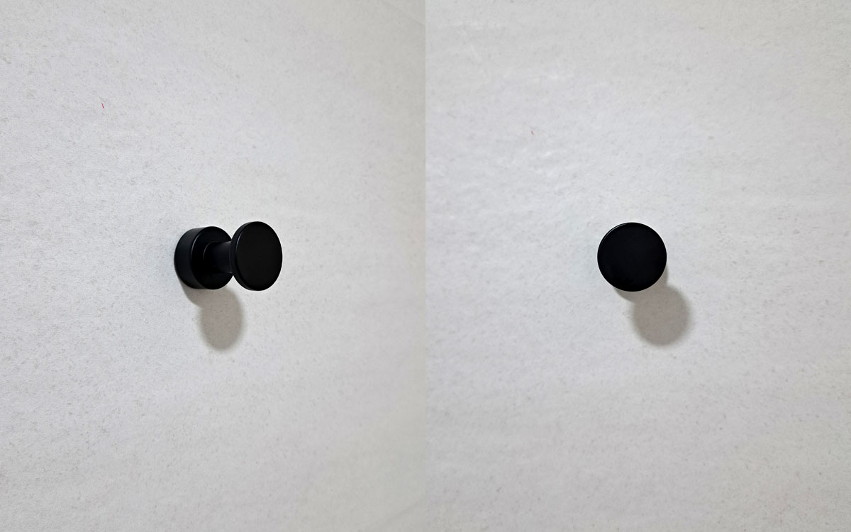 A single hook made of metal, nickel, screwed to a wall. Found on a museum in Porto, Portugal, 2025.