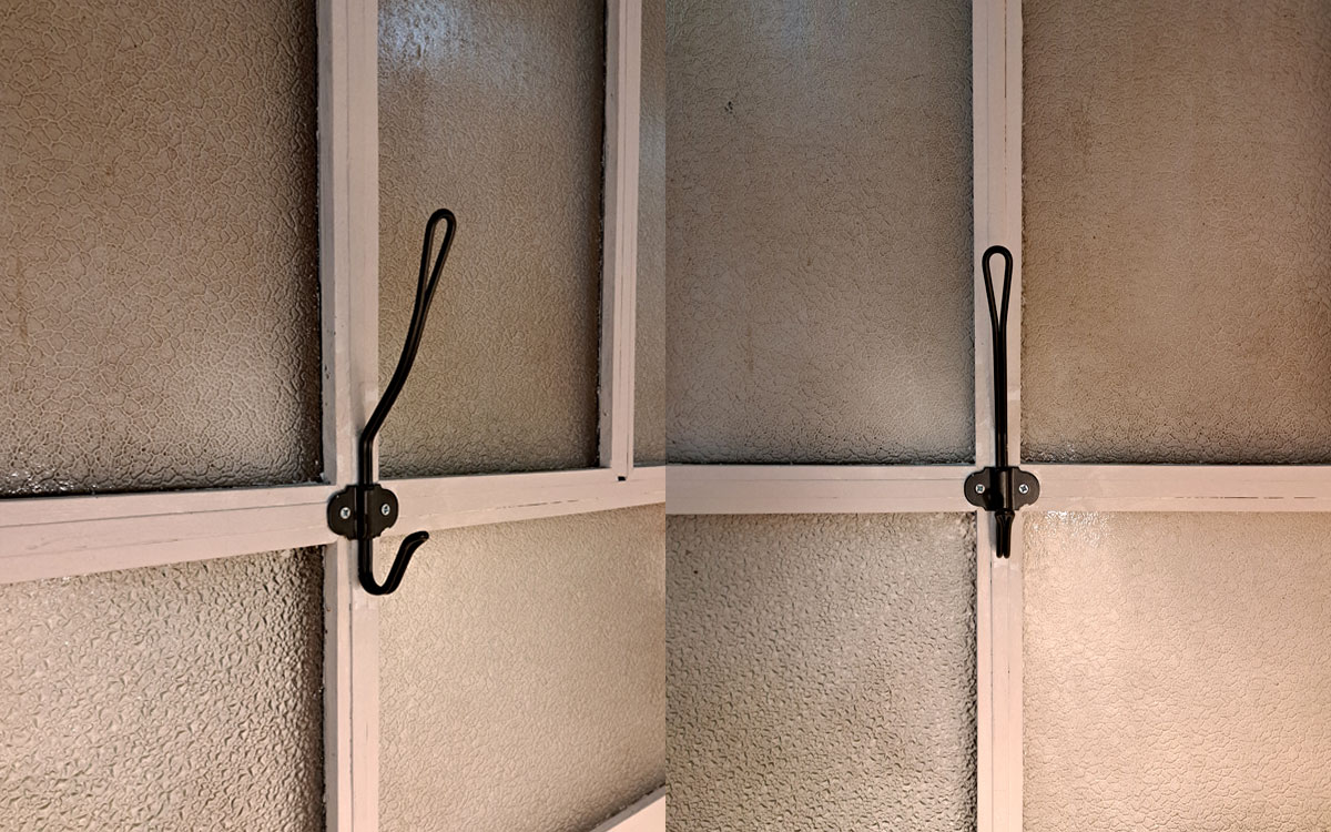 A double hook made of metal, nickel, screwed to a window frame. Found on a store in Porto, Portugal, 2025.