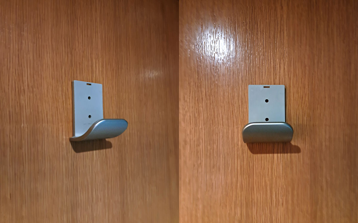 A single hook made of metal, nickel, screwed to a door. Found on a restaurant in Barcelona, Spain, 2025.