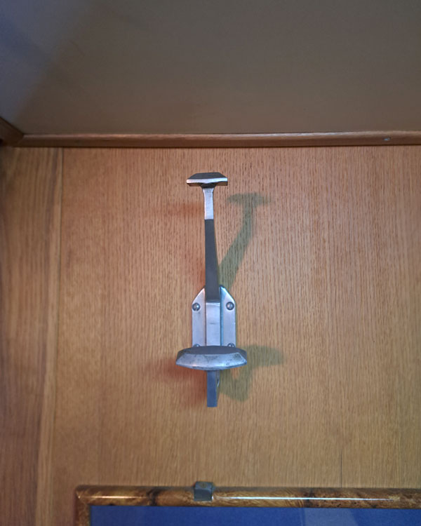 A double hook made of metal, nickel, screwed to a wall on a museum in Paris, France, 2026.
