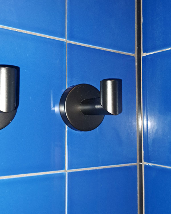 A single hook made of metal, black powder, fixed to a wall on a hotel in Bilbao, Spain, 2026.