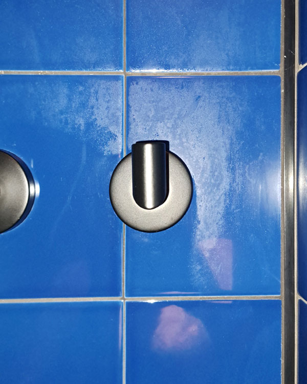 A single hook made of metal, black powder, fixed to a wall on a hotel in Bilbao, Spain, 2026.