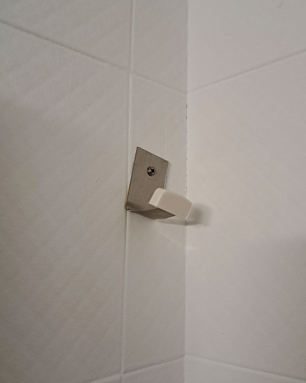 A single hook made of metal, screwed to a wall on a restaurant in Bilbao, Spain, 2026.
