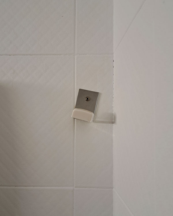 A single hook made of metal, screwed to a wall on a restaurant in Bilbao, Spain, 2026.